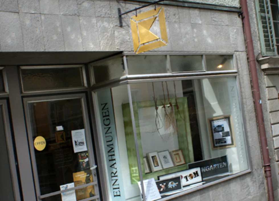 Schaufenster des Atelier König an der Marktgasse in Bremgarten, mit dem goldenen Ladenschild